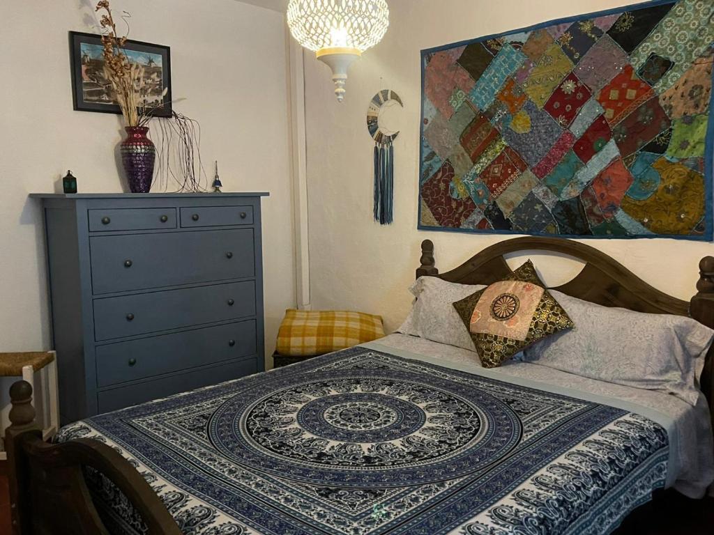 a bedroom with a bed with a dresser and a quilt at Casa La Maquica in Campo de Criptana