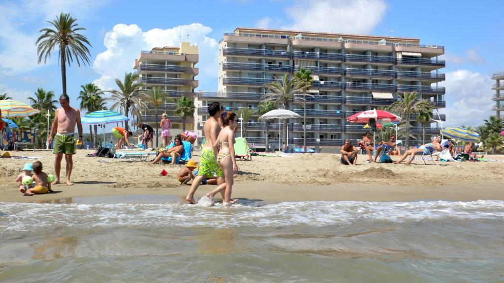 un grupo de personas de pie en la playa en Pompeya Vista Mar Orangecosta, en Peñíscola