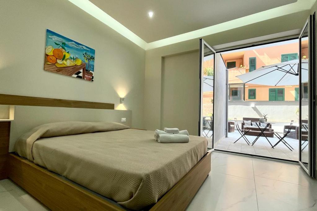 a bedroom with a bed and a view of a patio at Perle di Sicilia in Milazzo