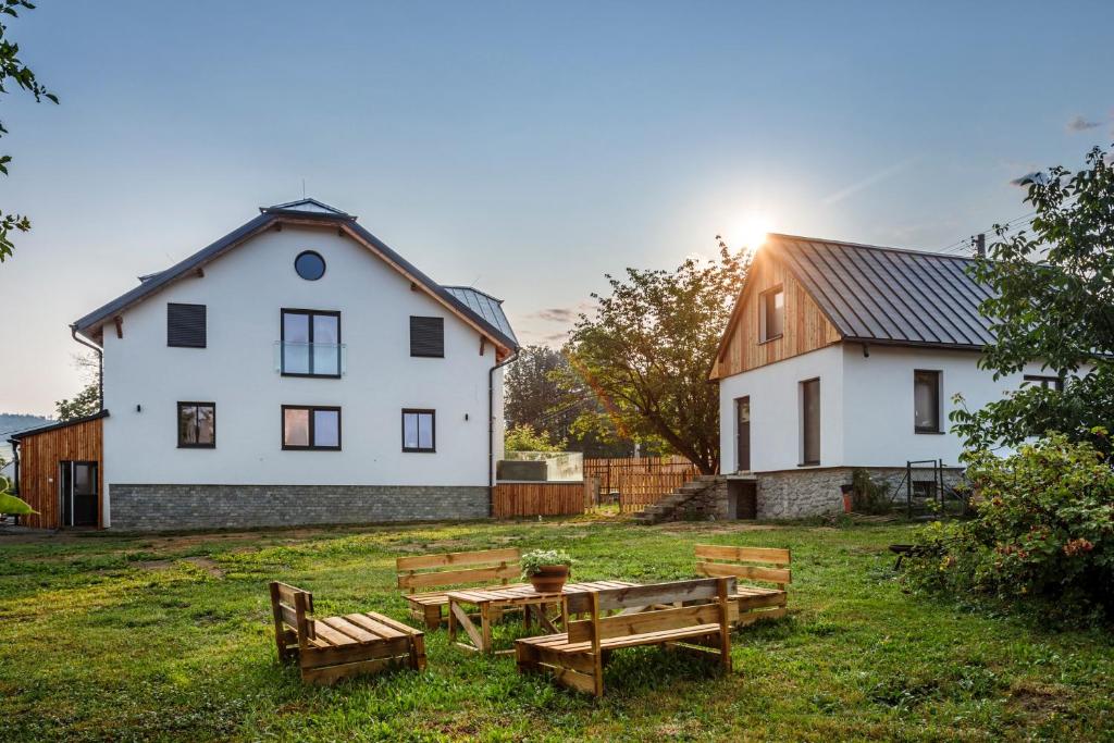 eine Gruppe von Bänken in einem Hof mit einem Haus in der Unterkunft Wellness Apartmány Vila Republika in Velké Losiny