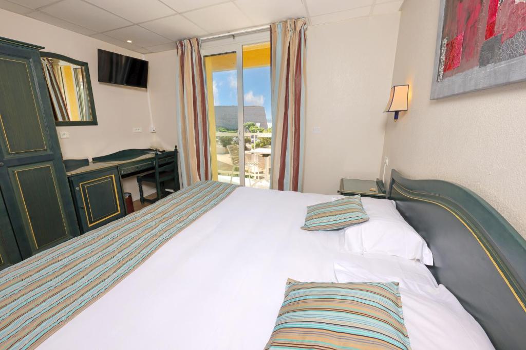 Postel nebo postele na pokoji v ubytování Hotel Saint Christophe