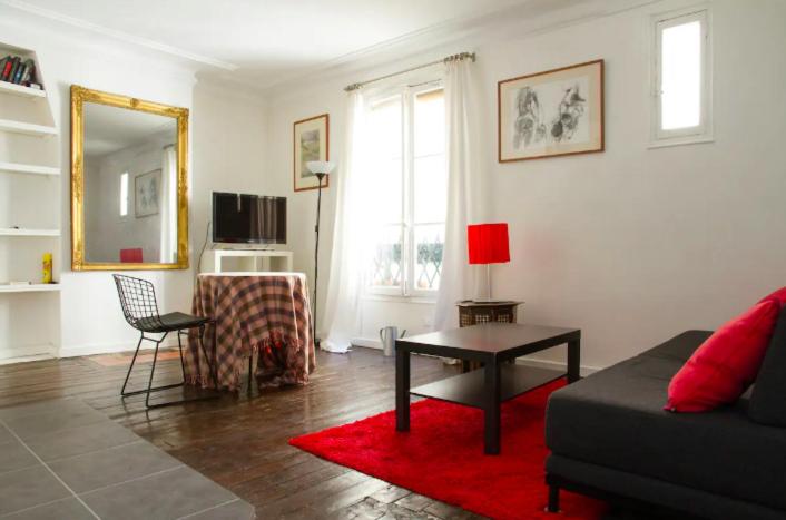 un salon avec un canapé et une table dans l'établissement Appartement proche Montmartre, à Paris