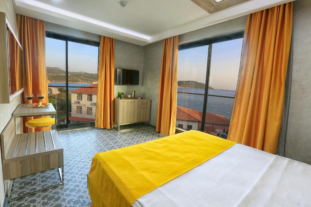 a bedroom with a bed and a large window at Erdem City Hotel in Kaş