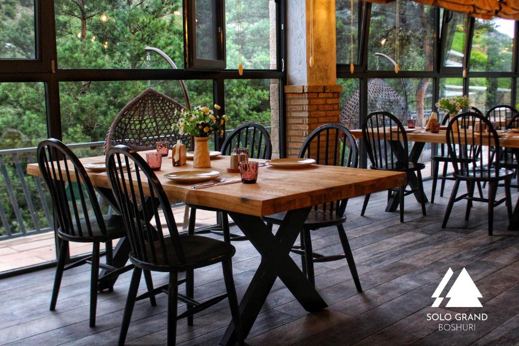 una mesa de madera y sillas en una habitación en Solo Grand Boshuri Hotel Wellness Resort en Gori