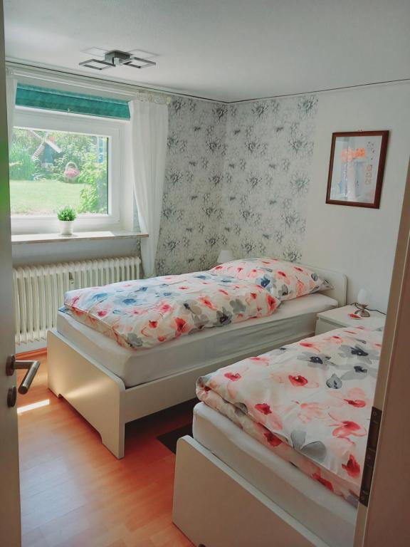 una camera con due letti e una finestra di Gemütliche 3 Zimmer-Ferienwohnung a Langelsheim
