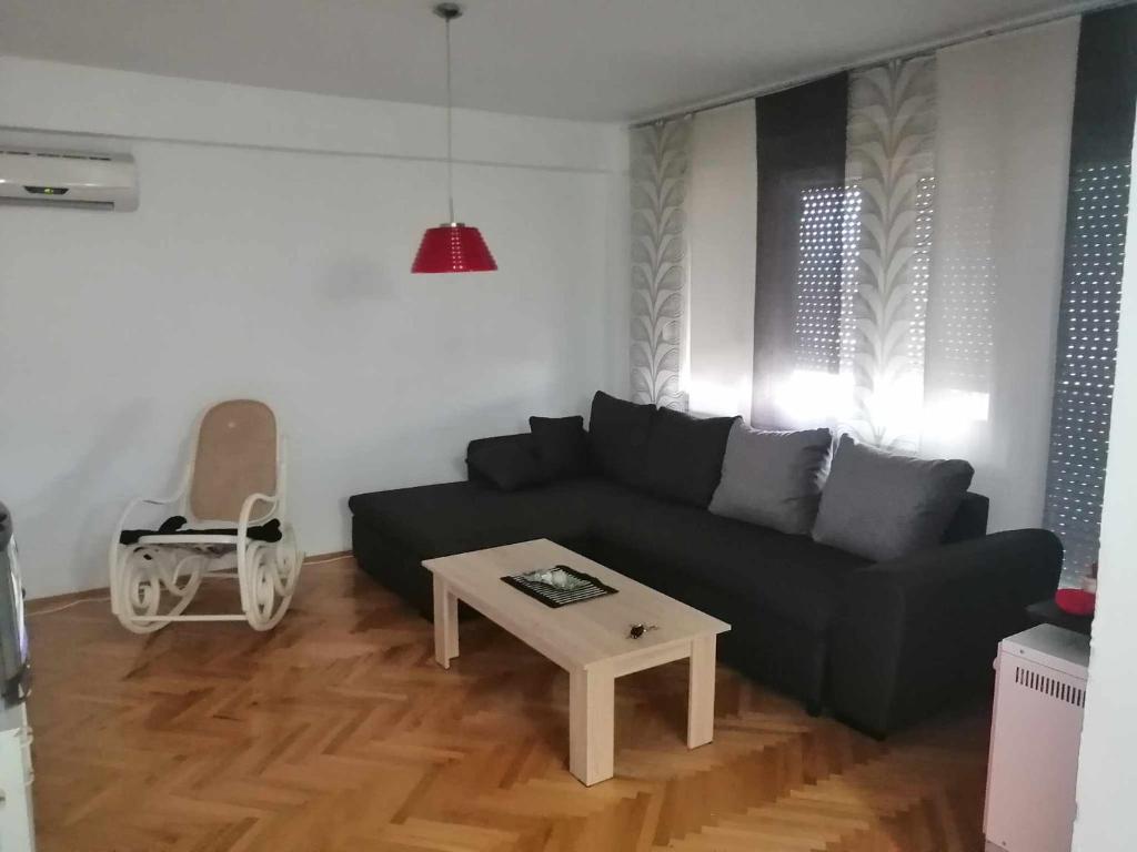 a living room with a black couch and a table at ANAHOME in Gevgelija