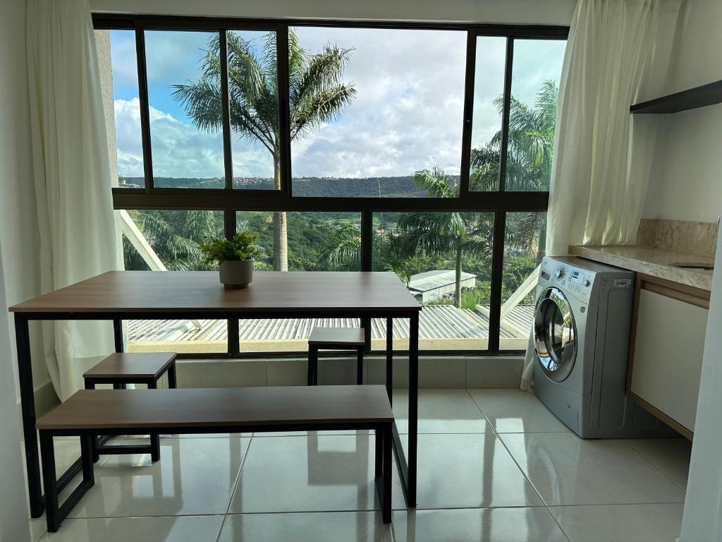 a kitchen with a table and a washing machine at Apartamento Encantador em Bananeiras in Bananeiras