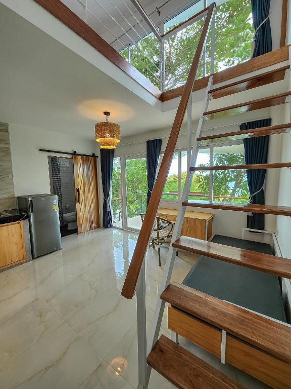 a living room with a spiral staircase in a house at Haadson Resort & Koh Raham in Haad Son