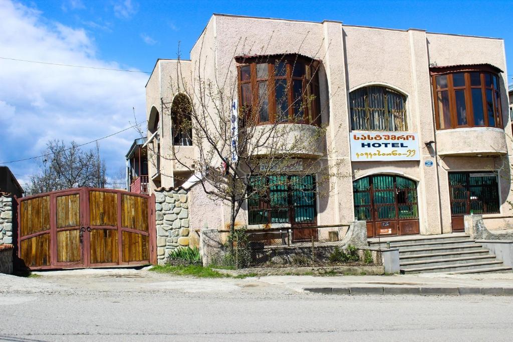 an old building with a wooden gate and a fence at Guest House Kavkasioni 33 in Tʼelavi