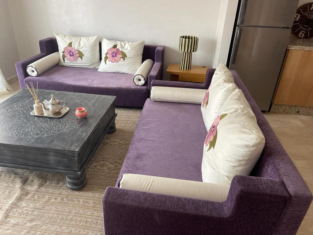 ein Wohnzimmer mit zwei lila Sofas und einem Tisch in der Unterkunft Appartement gueliz Majorelle in Marrakesch