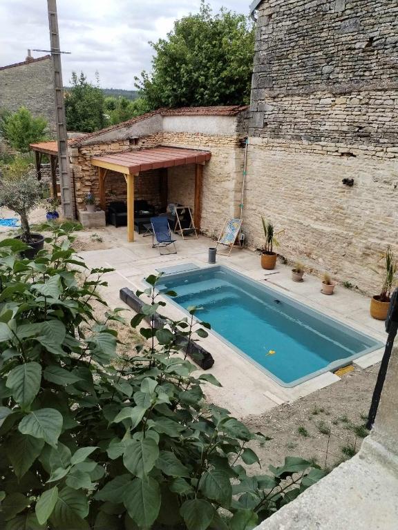 basen w ogrodzie obok budynku w obiekcie chambres d'hôtes rue Pasteur w mieście Is-sur-Tille