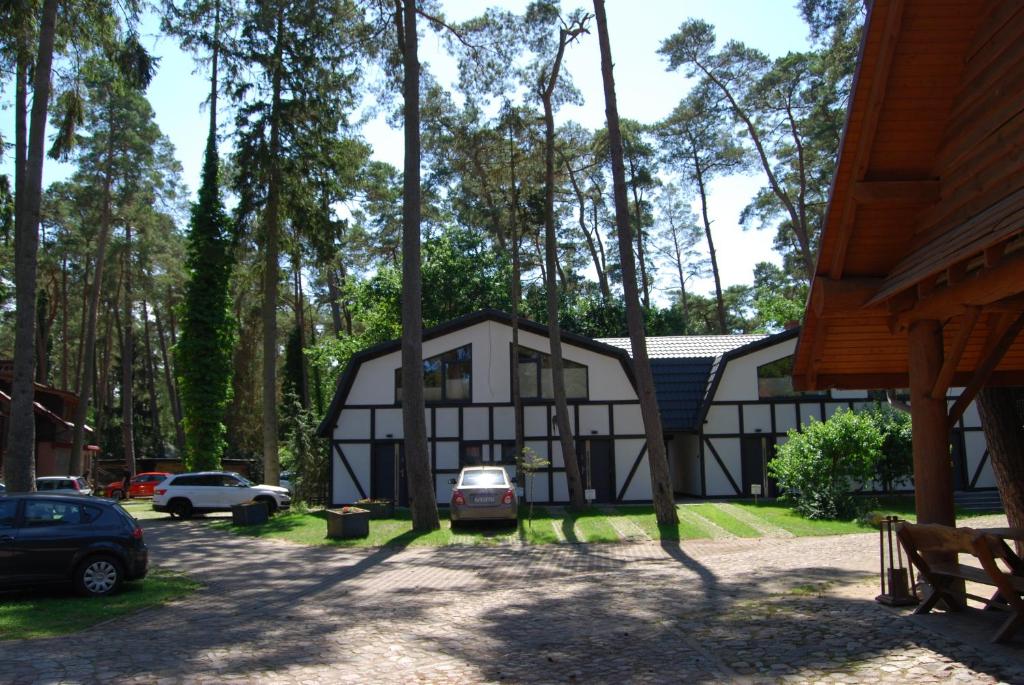 a house in the woods with cars parked in front at Kotwica Morska in Pobierowo
