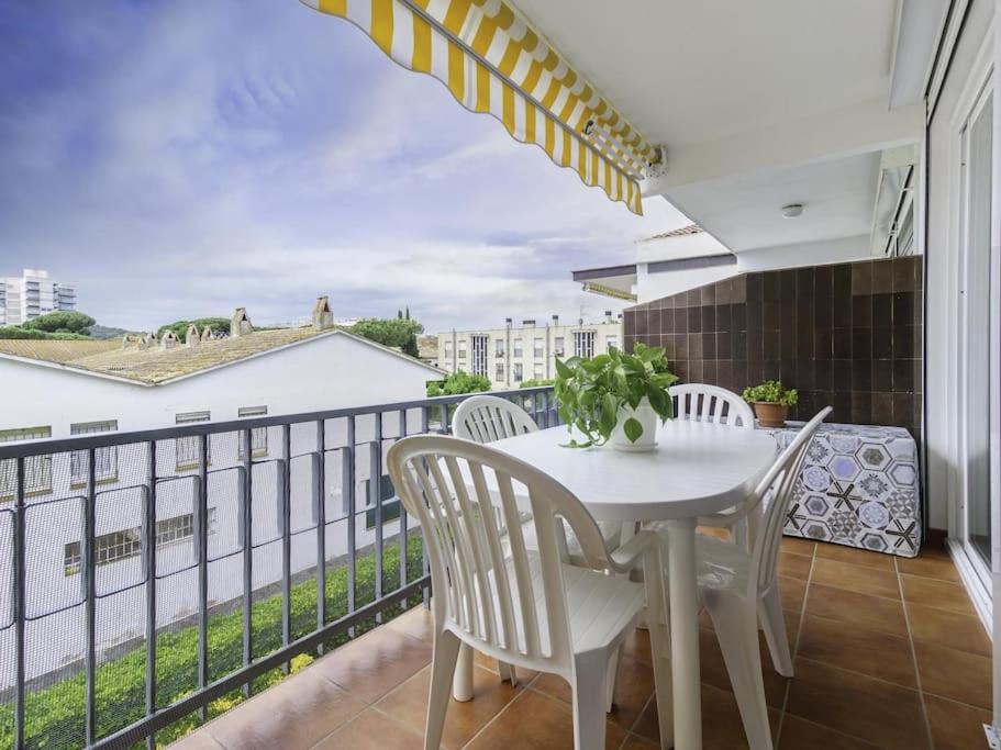 una mesa blanca y sillas en un balcón con vistas en Piso ideal para dos con balcón Platja d'Aro, en Platja d'Aro