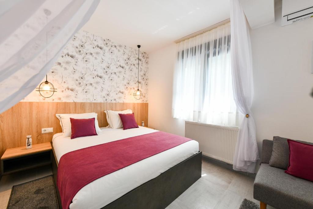 a hotel room with a large bed and a window at Villa Elena in Grabovac
