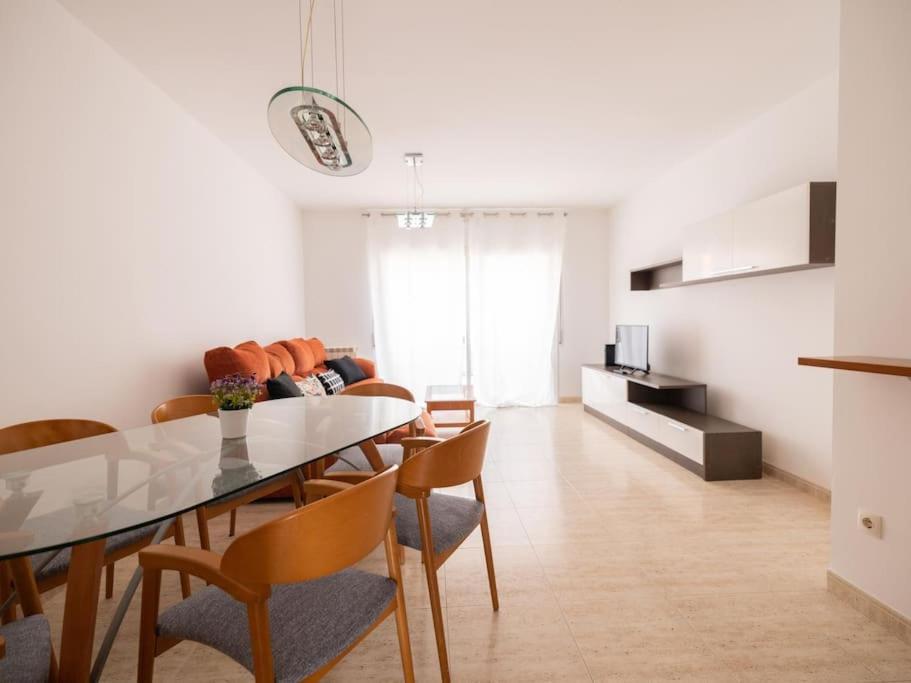 Fantástico y acogedor apartamento en Sant Feliu في سان فيليو دي غيكسولس: غرفة طعام وغرفة معيشة مع طاولة وكراسي