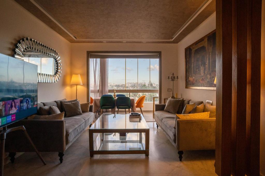 un soggiorno con divano e tavolo di Luxury golden view apartment in les terrasses danfa ain diab a Casablanca