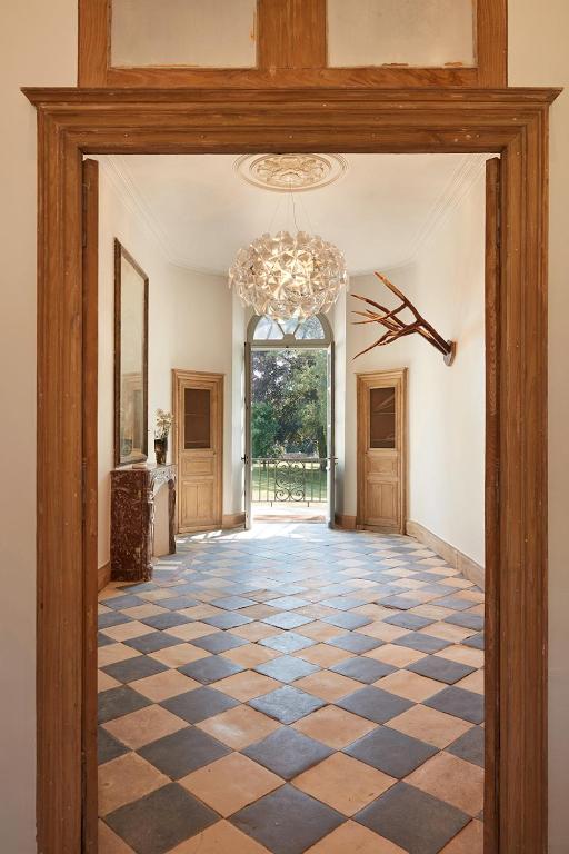 a hallway with a checkered floor and a chandelier at DOMAINE LE MEZO in Ploeren