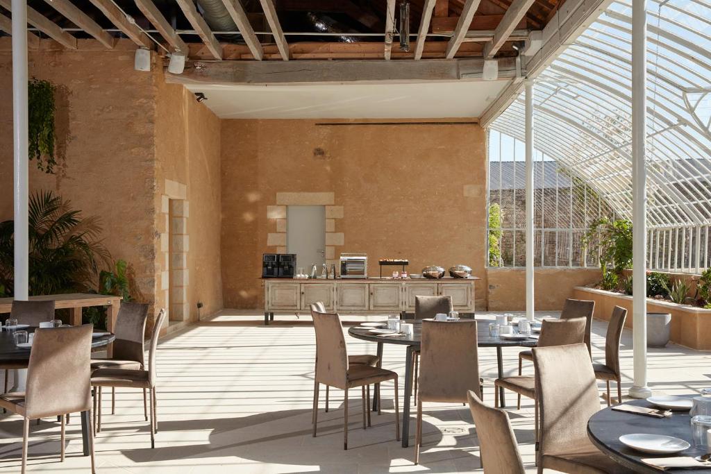 a restaurant with tables and chairs in a building at DOMAINE LE MEZO in Ploeren