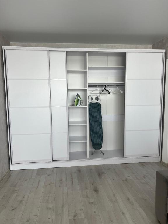 a white closet with white doors and a shelf at Квартира в центре, новострой in Chernihiv