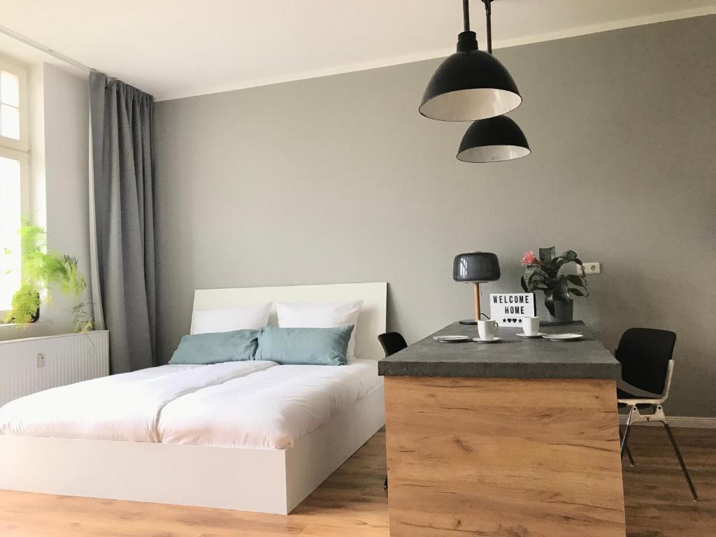 um quarto com uma cama branca e um candeeiro preto em Charmantes Loft mit Balkon em Magdeburg