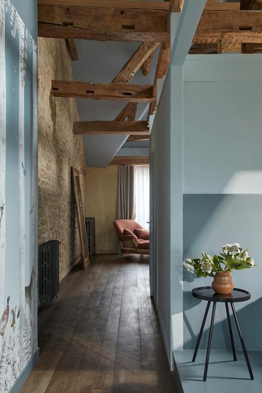 a hallway with a table and a chair in a room at DOMAINE LE MEZO in Ploeren