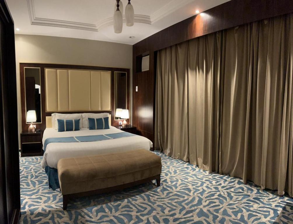 a hotel room with a large bed and a couch at فندق وايت هافن in Sūq al Aḩad