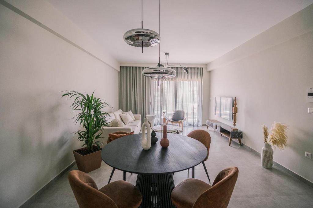 sala de estar con mesa y sillas en HAMA Luxury Seaside Apartments en Kórinthos