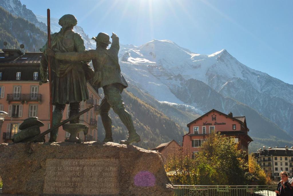 a statue of two people with a mountain in the background at Hôtel Vallée Blanche in Chamonix-Mont-Blanc