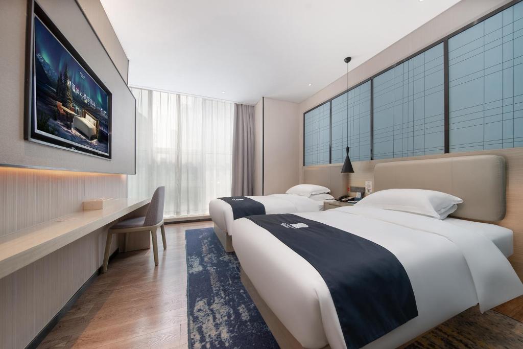 Postel nebo postele na pokoji v ubytování Echarm International Hotel Canton Tower Pazhou Convention and Exhibition Center Lujiang Subway Metro Branch - Free Shuttle Bus to Canton Fair Complex During Canton Fair Period