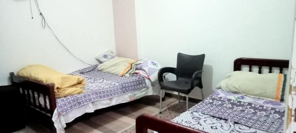 - une chambre avec 2 lits jumeaux et une chaise dans l'établissement العجمي البيطاش, à Alexandrie