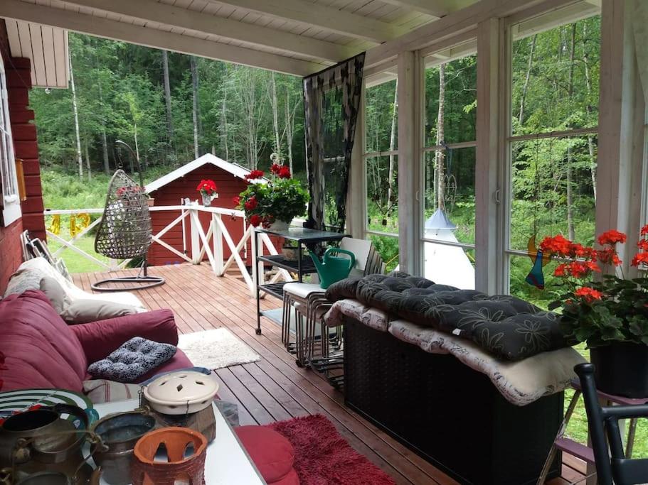a screened in porch with a couch and a table at Cottage / Mökki, unique summer cottage in Vihti