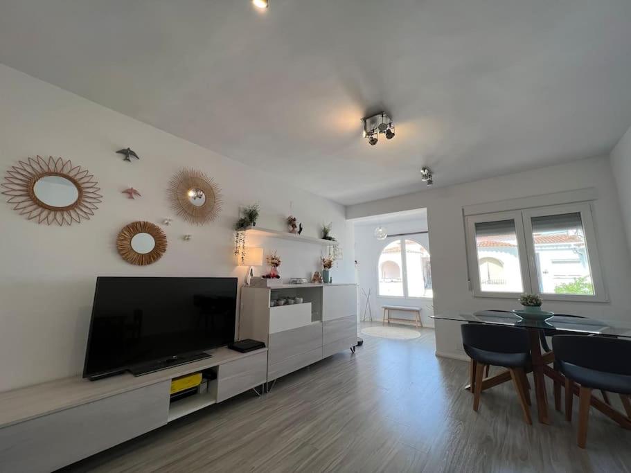 uma sala de estar com uma televisão de ecrã plano e uma mesa em Apartamento cerca de la playa em Denia