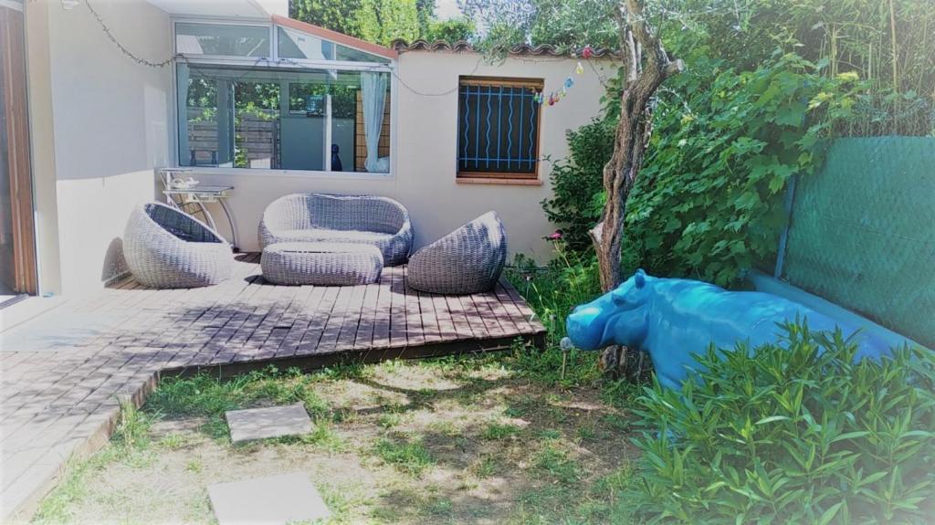 a patio with a blue cow statue in the yard at Antibes Port de Salis Appart 3p in Antibes