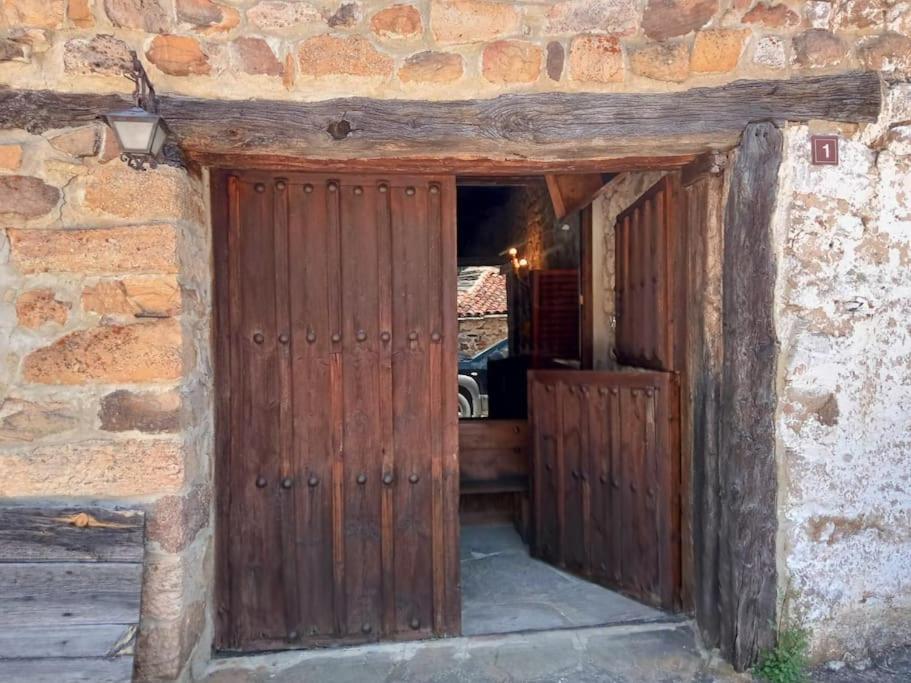 einen Eingang zu einem Steingebäude mit einer Holztür in der Unterkunft El Refugio de Molinos de Razón. in Molinos de Razón