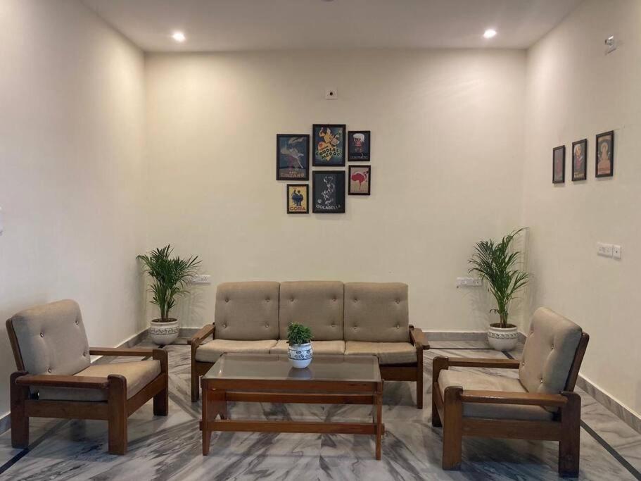 a waiting room with couches and a table and chairs at Zoeys Homestay - 1BHK with Free Breakfast in Jammu