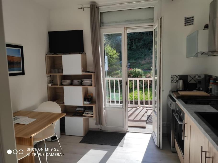a kitchen with a door leading to a balcony at Studio Tribord Le Tréport - vue mer & falaises in Le Tréport