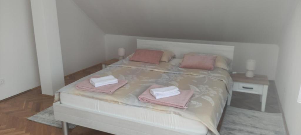 una camera da letto con un letto e asciugamani rosa di Katty-Rastoke a Slunj
