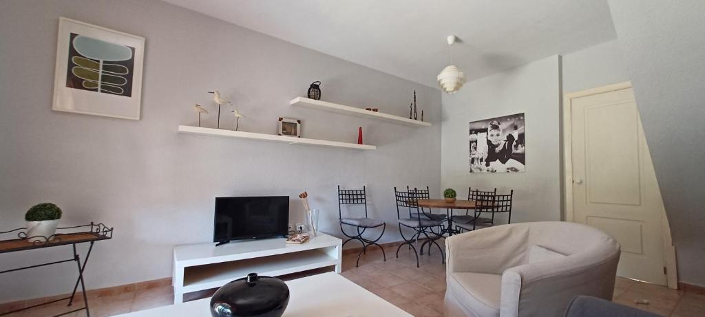 uma sala de estar com um sofá e uma televisão em Adosado en Islantilla na Islantilla