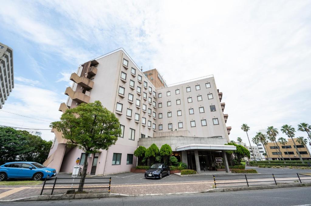 a building with a car parked in front of it at Kagoshima Daiichi Hotel Kamoike in Kagoshima