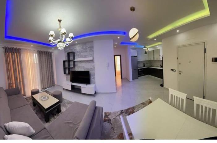 een grote woonkamer met een bank en een tafel bij Best Apartments in Elbasan