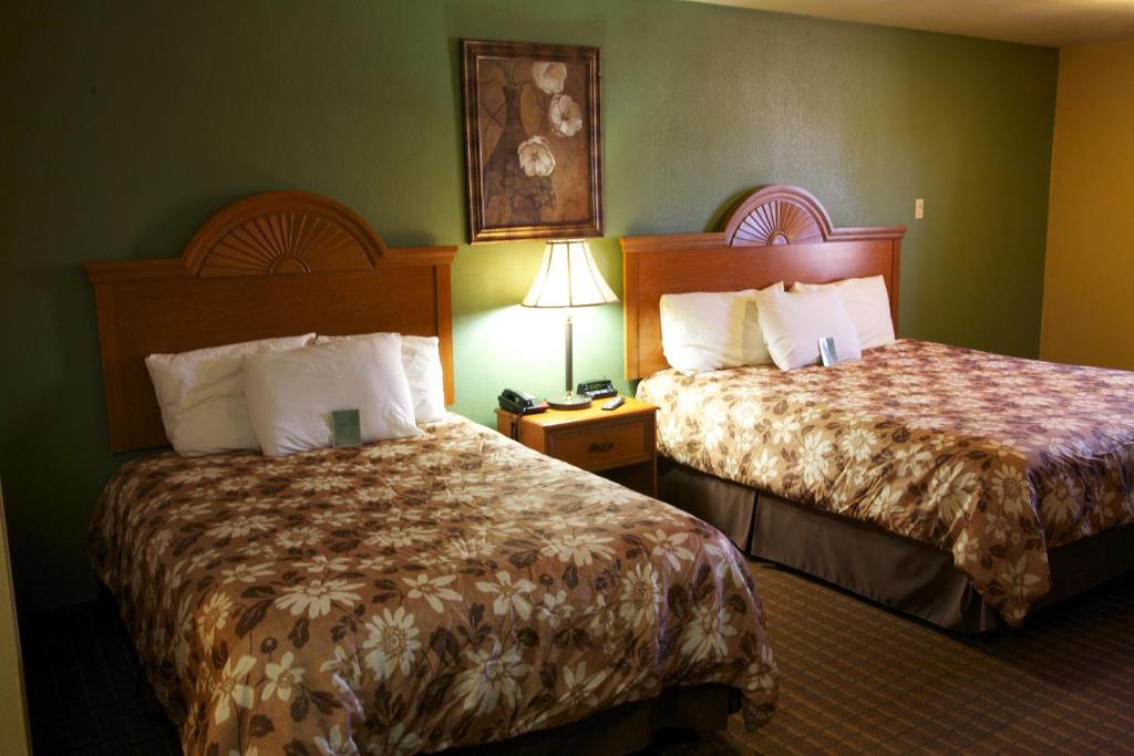 una habitación de hotel con 2 camas y una lámpara en Coach Light Inn, en Brenham