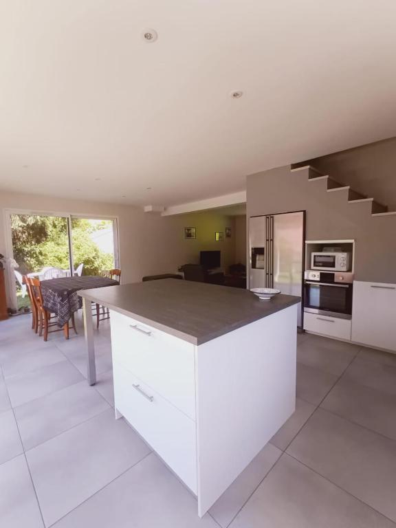 - une cuisine avec une grande île blanche dans une chambre dans l'établissement 15mn grenoble-30mn vercors wifi gratuit-6personnes vue vercors, à Fontanil-Cornillon