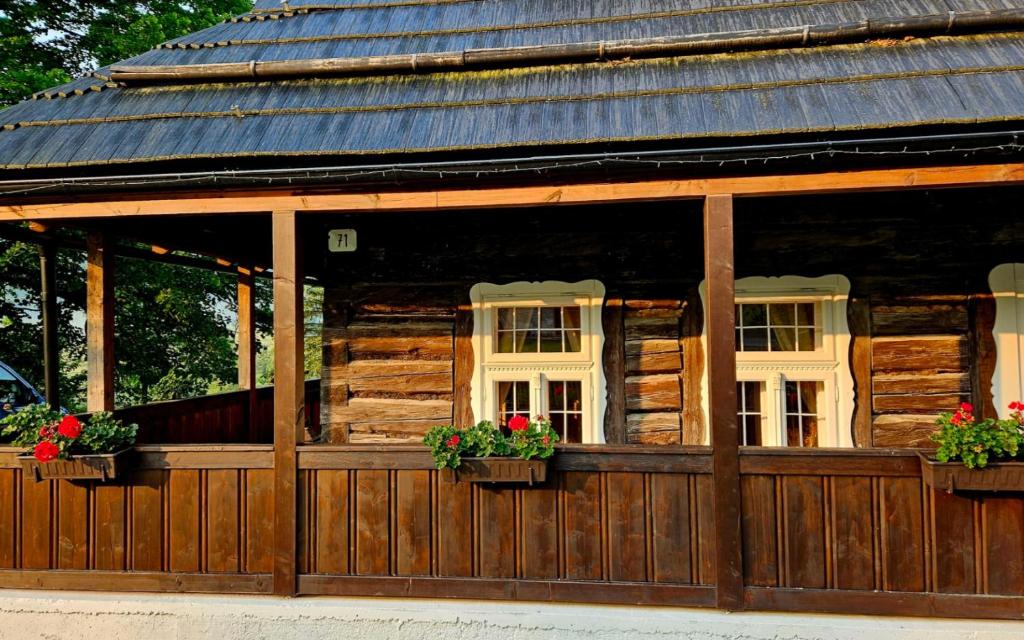 ein Blockhaus mit zwei Fenstern und Blumen darauf in der Unterkunft Drevenica Borovianka in Veľké Borové
