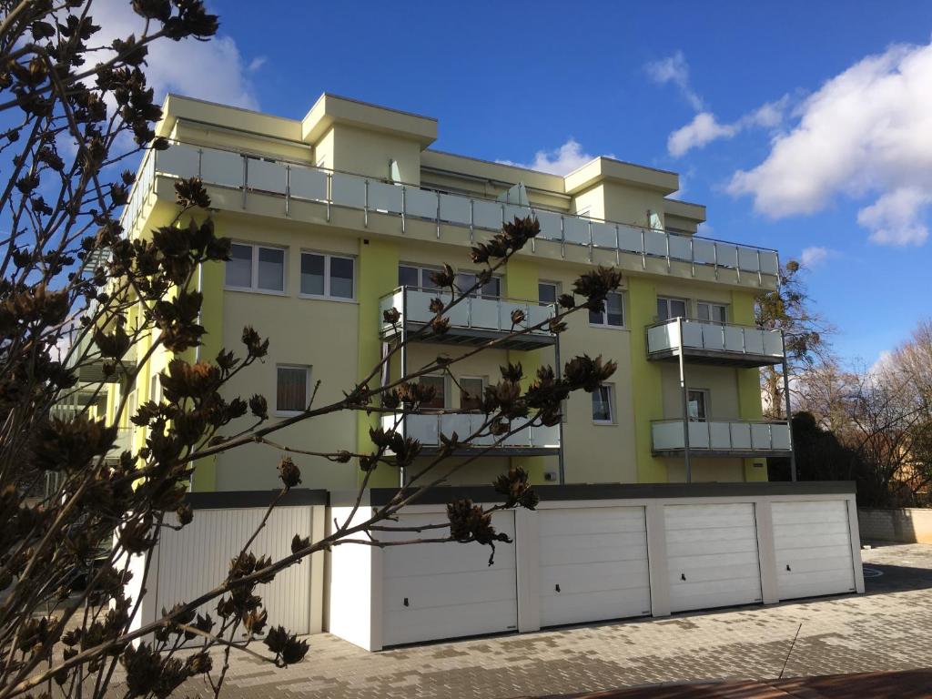 una casa amarilla con garaje blanco en Ferienwohnung am Park, en Lahr