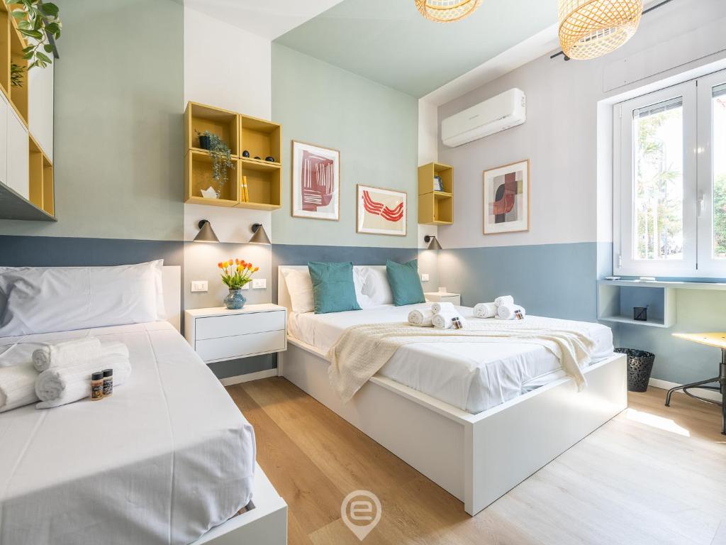 two beds in a bedroom with blue and white walls at Is Arenas Biancas Apartment in Teulada