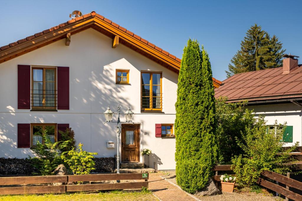 uma casa branca com um telhado vermelho em Ferienhaus Weinklause am Plattenbichl em Oberstdorf