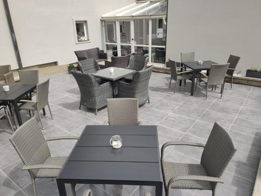 um restaurante com mesas e cadeiras pretas e mesas e cadeiras em Apartmán Markéta em Lipno nad Vltavou