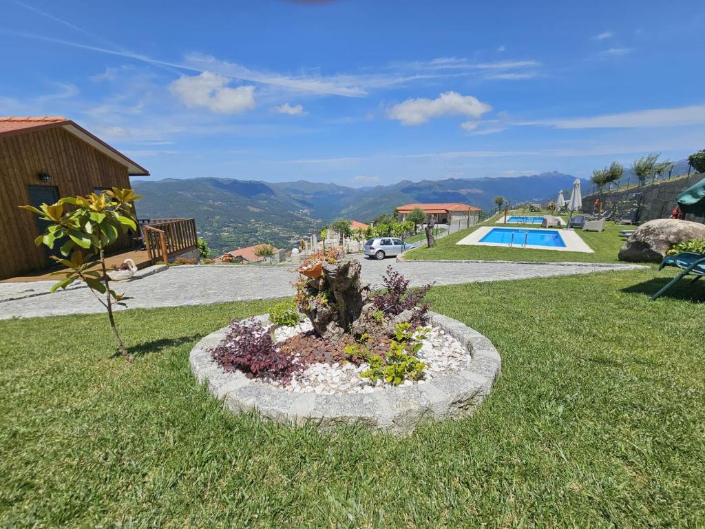 a flower bed in the grass next to a pool at Casa do Iteiro in Caniçada