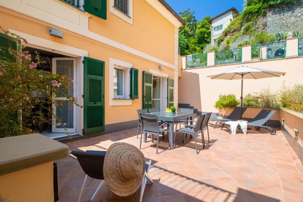 波托菲諾的住宿－Elios by PortofinoHomes，庭院配有桌椅和遮阳伞。