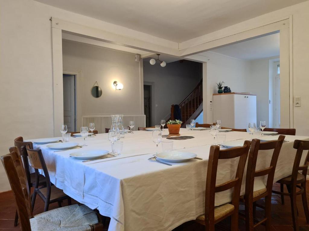 Saint-MarcelにあるGîte LE MAGE - maison de retrouvaillesの長テーブル(椅子付)、白いテーブルクロス